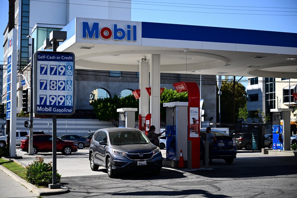 A customer uses a credit card to pump gas as a sign shows gasoline fuel prices above average at over seven and approaching eight dollars a gallon at a Mobil gas station in Los Angeles, California, on October 5, 2023.