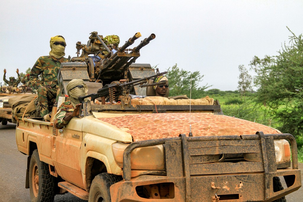 Fighters in a military convoy accompanying the governor of Sudan's Darfur State through Gedaref city on their way to Port Sudan