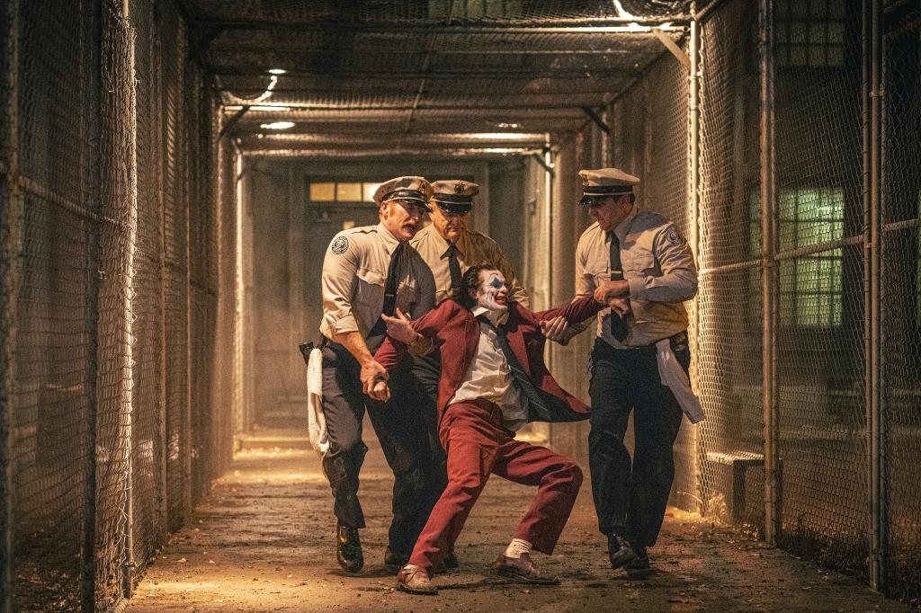 Joaquin Phoenix's joker restrained by three cops