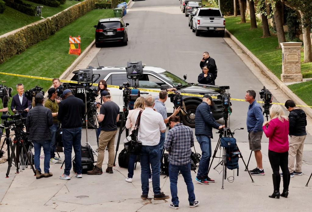 Media members work as law enforcement officers stand behind police tape outside a property connected to hip-hop star Sean "Diddy" Combs after U.S. Department of Homeland Security agents opened an investigation, in the Holmby Hills neighborhood of Los Angeles, California, U.S. March 25, 2024.