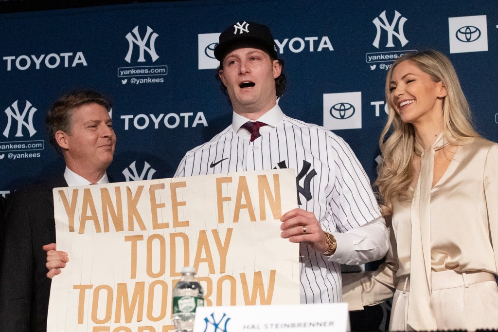 Gerrit Cole (center) held his famous Yankees sign upon being introduced by the team in December 2019.