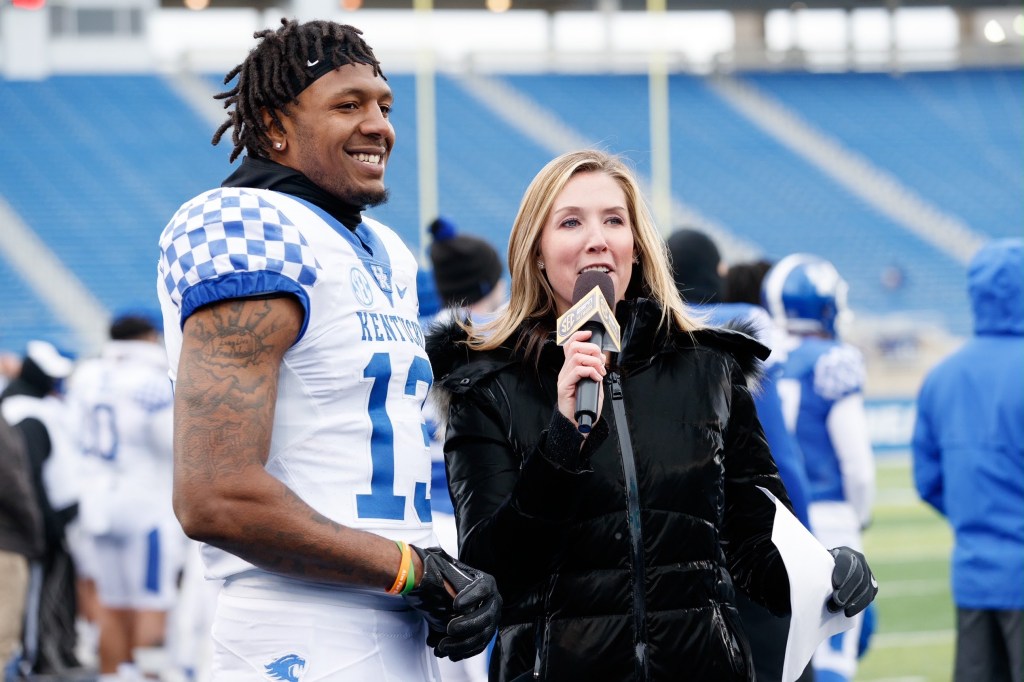 Lauren Sisler interviewing JJ Weaver, in University of Kentucky uniform, on the sidelines of a football field