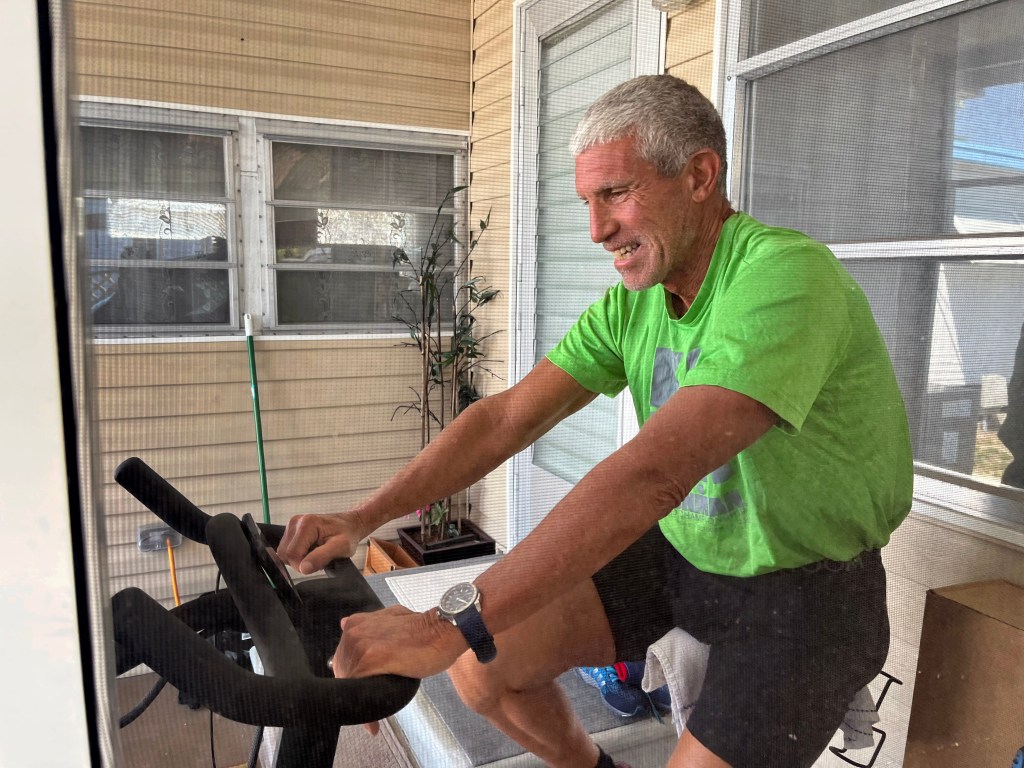 Singer works out on a Peloton bike at his house in the Isle of Palms mobile home park in St. Petersburg, Fl. on June 23, 2022.