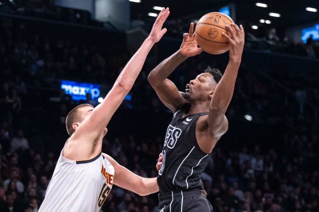 Nets forward Dorian Finney-Smith (28) shoots over Denver Nuggets center Nikola Jokic (15) in the first half at Barclays Center, Friday, Dec. 22, 2023