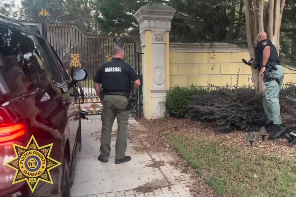 Officers stand outside the gate of the mansion.