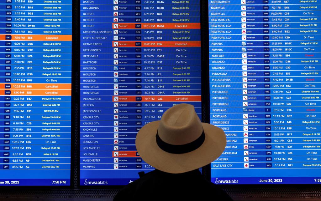 Travelers check the status of their flights ahead of the July 4th holiday weekend at Ronald Reagan Washington National Airport in Arlington, Virginia.