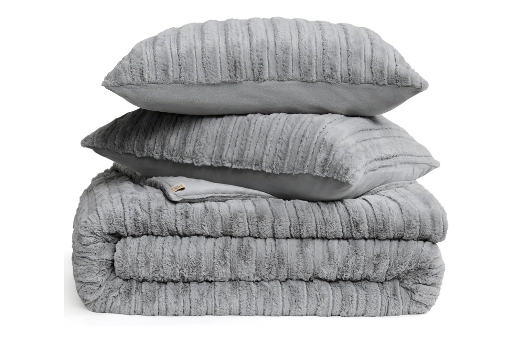 A stack of grey pillows and blankets