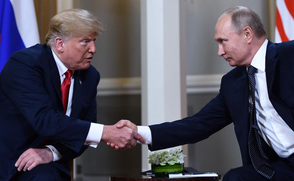 Donald Trump and Vladimir Putin shake hands before a meeting in Helsinki in July 2018.