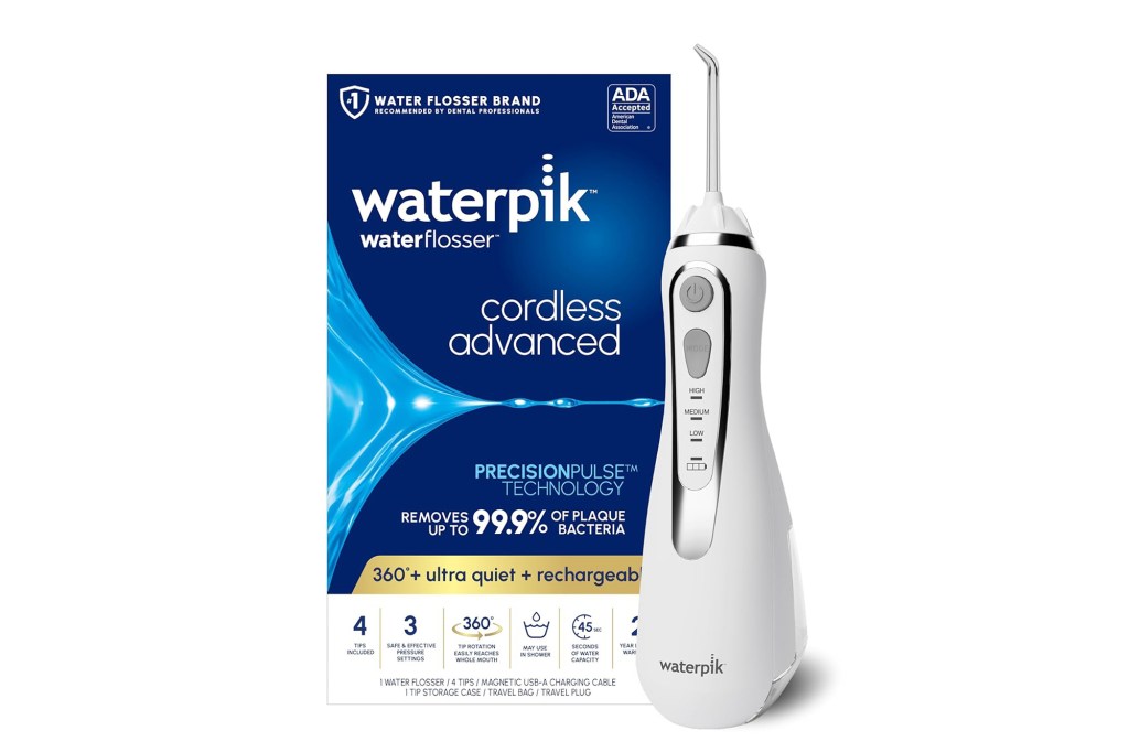 A white electric Waterpik toothbrush alongside a blue and white box