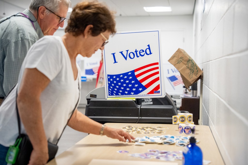 A woman picks out a sticker after voting on the first day of Virginia's in-person early voting at Long Bridge Park Aquatics and Fitness Center on September 20, 2024 in Arlington, Virginia.