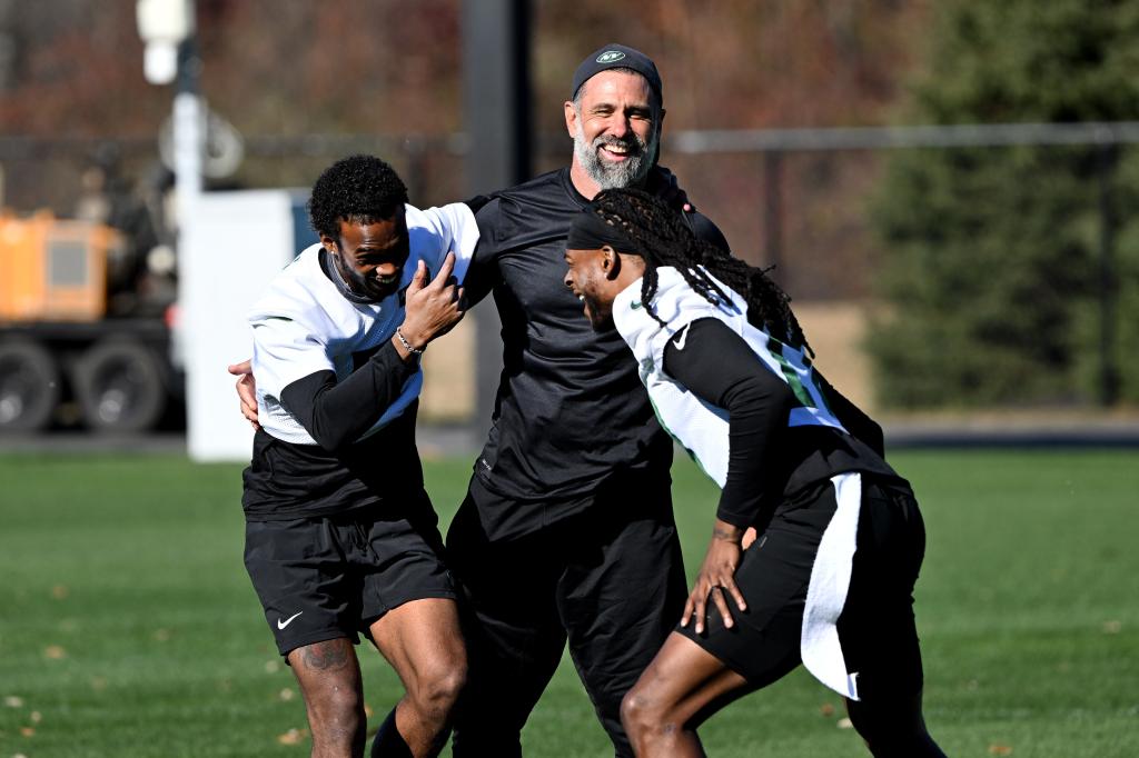 Jets interim coach Jeff Ulbrich hugs wide receivers Garrett Wilson (5) and  Davante Adams (17) at practice in Florham Park, NJ. 