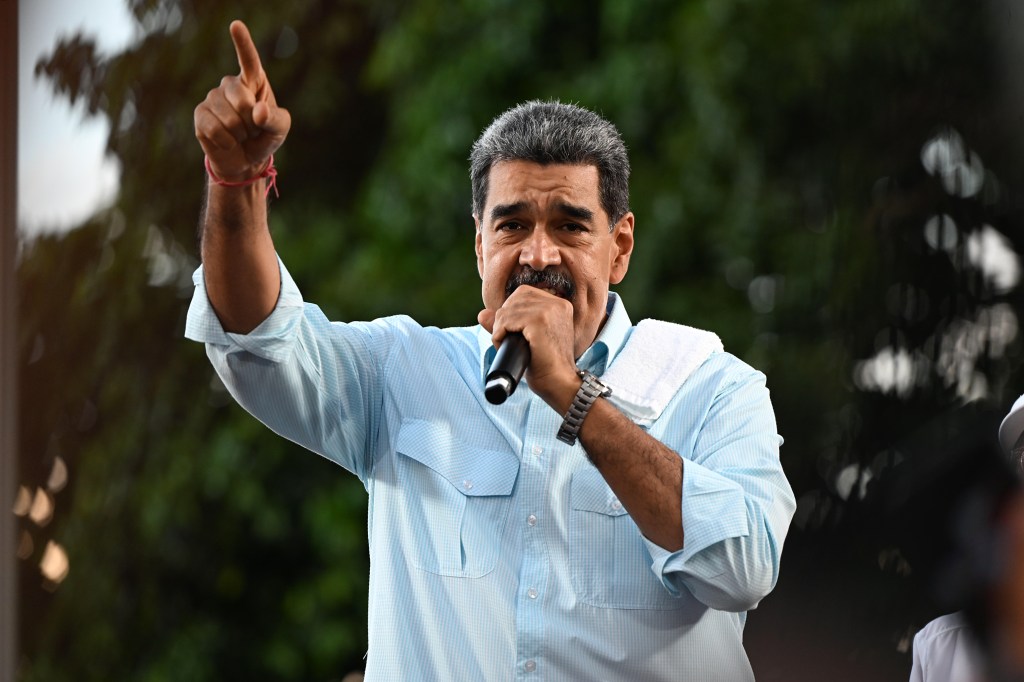 President of Venezuela Nicolás Maduro raises his hand in a speech during the 'Gran Marcha Mundial por la Paz' supporting Maduro on August 17, 2024 in Caracas, Venezuela.