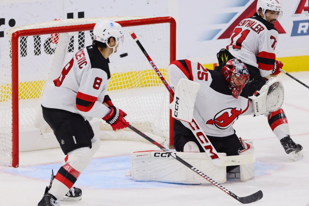 New Jersey Devils goaltender Jacob Markstrom (25) deflects a shot against the Florida Panthers during the third period at Amerant Bank Arena.