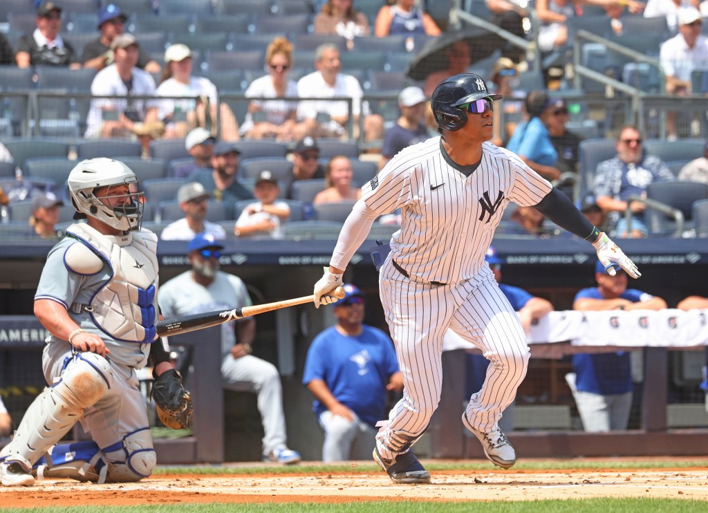 Juan Soto #22 of the New York Yankees hits a single against the Toronto Blue Jays.