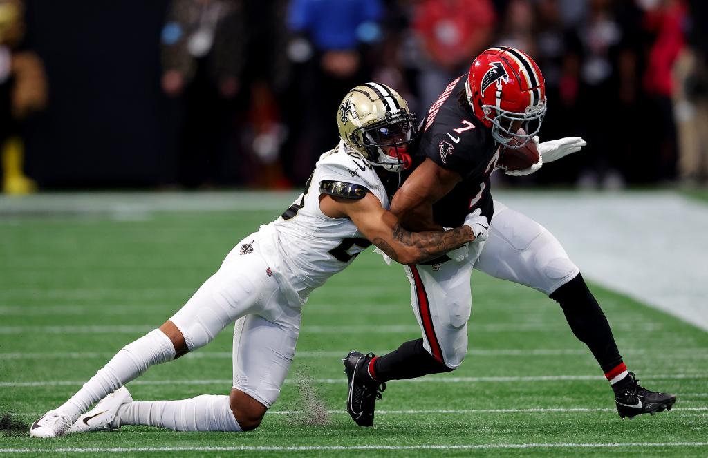 Bijan Robinson (7) of the Atlanta Falcons is tackled by Marshon Lattimore (23) of the New Orleans Saints during the first quarter at Mercedes-Benz Stadium on September 29, 2024 in Atlanta, Georgia. 