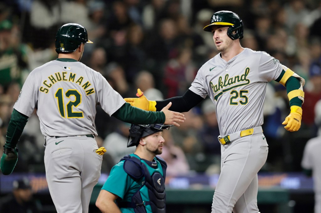 Oakland Athletics' Brent Rooker and Max Schuemann celebrating a two-run home run during a game against the Seattle Mariners