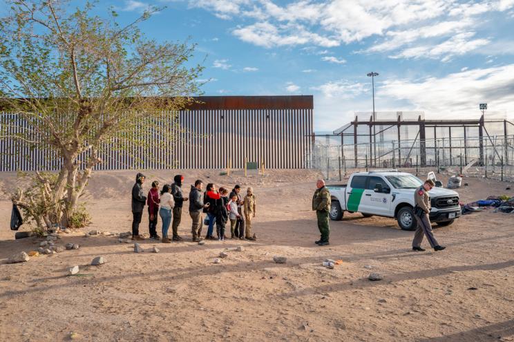 A group of migrants wait to be processed after crossing the Rio Grande river on April 02, 2024 in El Paso, Texas.