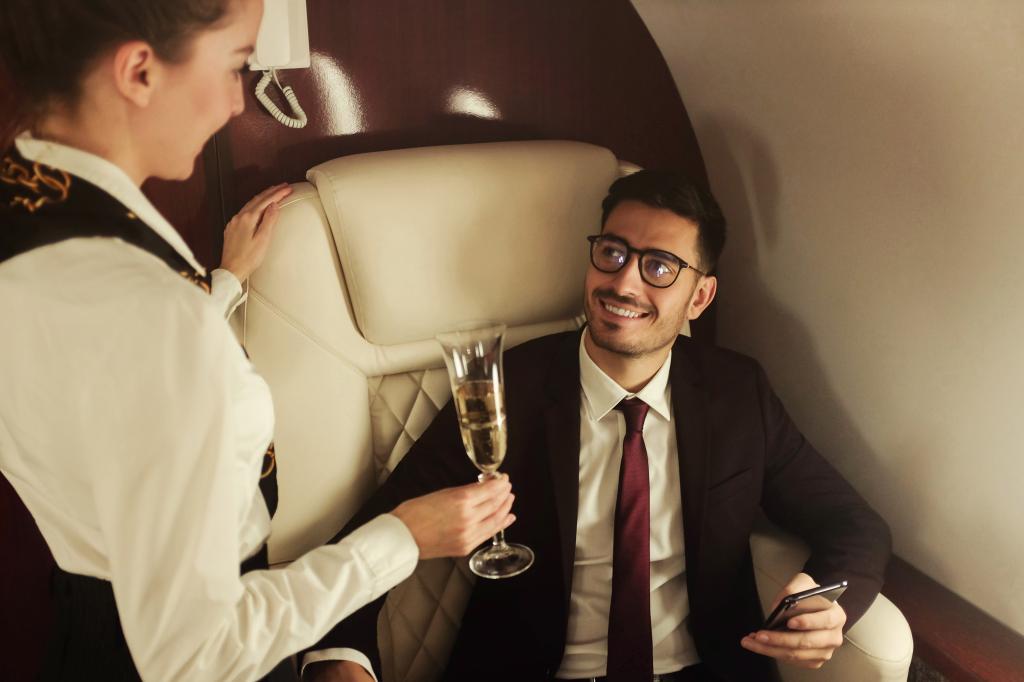 A man conversing with a flight attendant while in first class. 