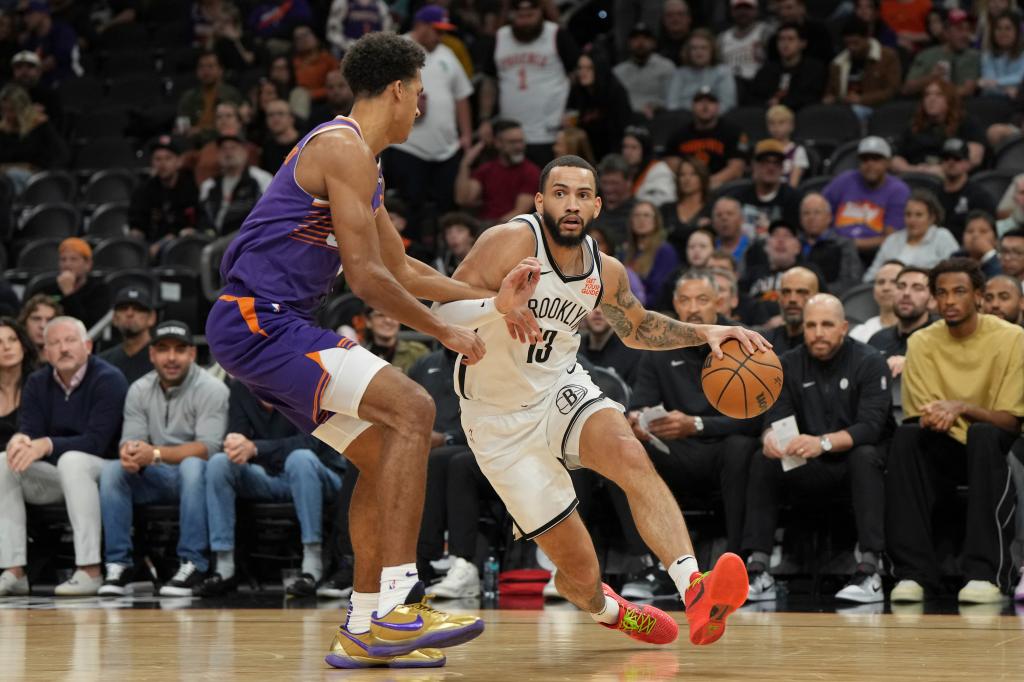 Brooklyn Nets guard Tyrese Martin driving with the ball against Phoenix Suns center Oso Ighodaro during an NBA game