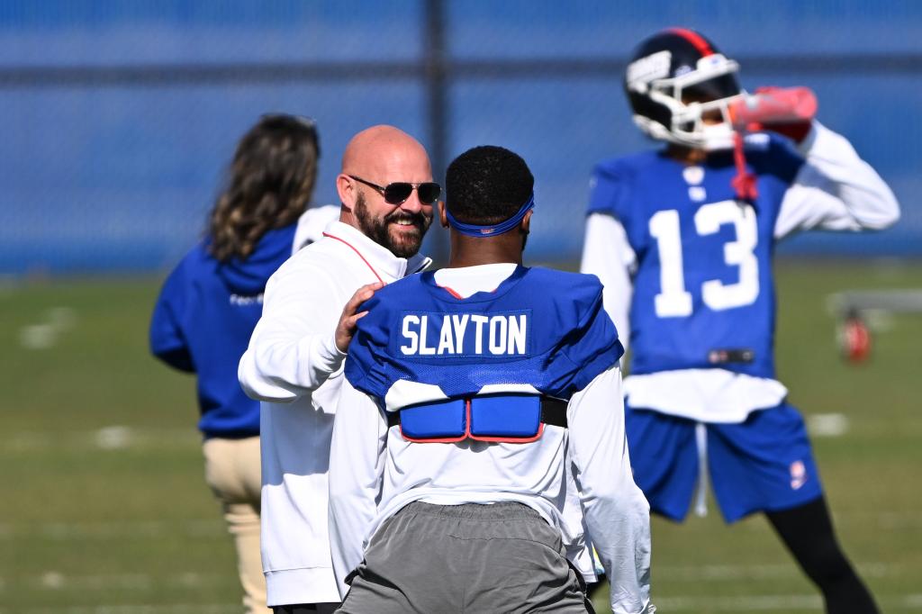 Giants coach Brian Daboll talks with wide receiver Darius Slayton (86) before practice