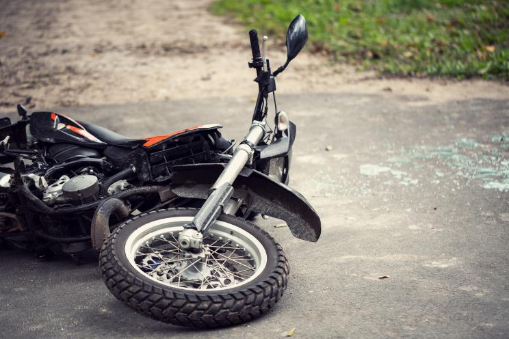 Broken motorcycle lying on the road after a traffic incident