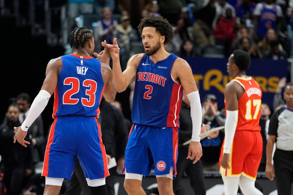 Detroit Pistons guard Cade Cunningham interacting with teammate Jaden Ivey after making a game-winning basket in an NBA game against the Atlanta Hawks