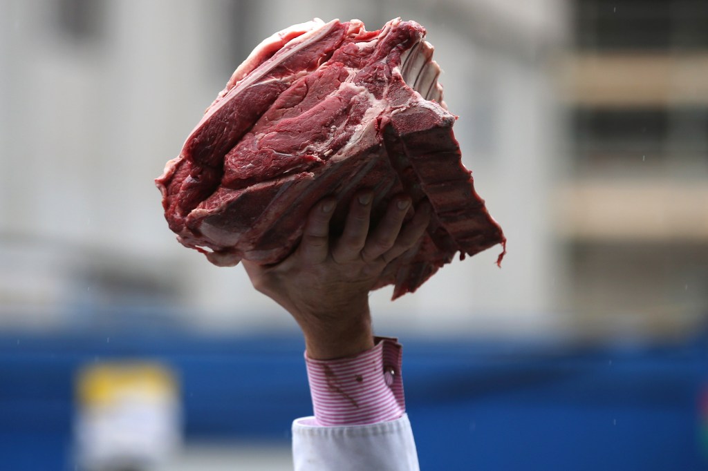 A customer holding a joint of meat bought from the annual Harts' Christmas Meat Auction at London's Smithfield Market