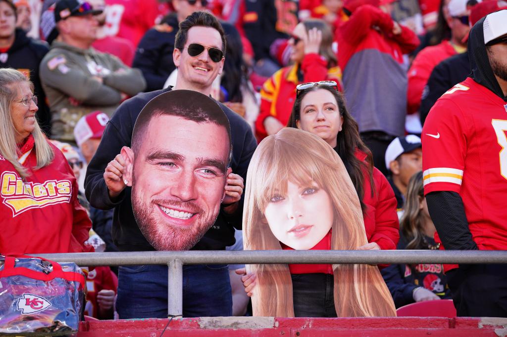 Chiefs fans hold fathead signs of Travis Kelce (not pictured) and Taylor Swift during the second half of the game against the Denver Broncos at GEHA Field