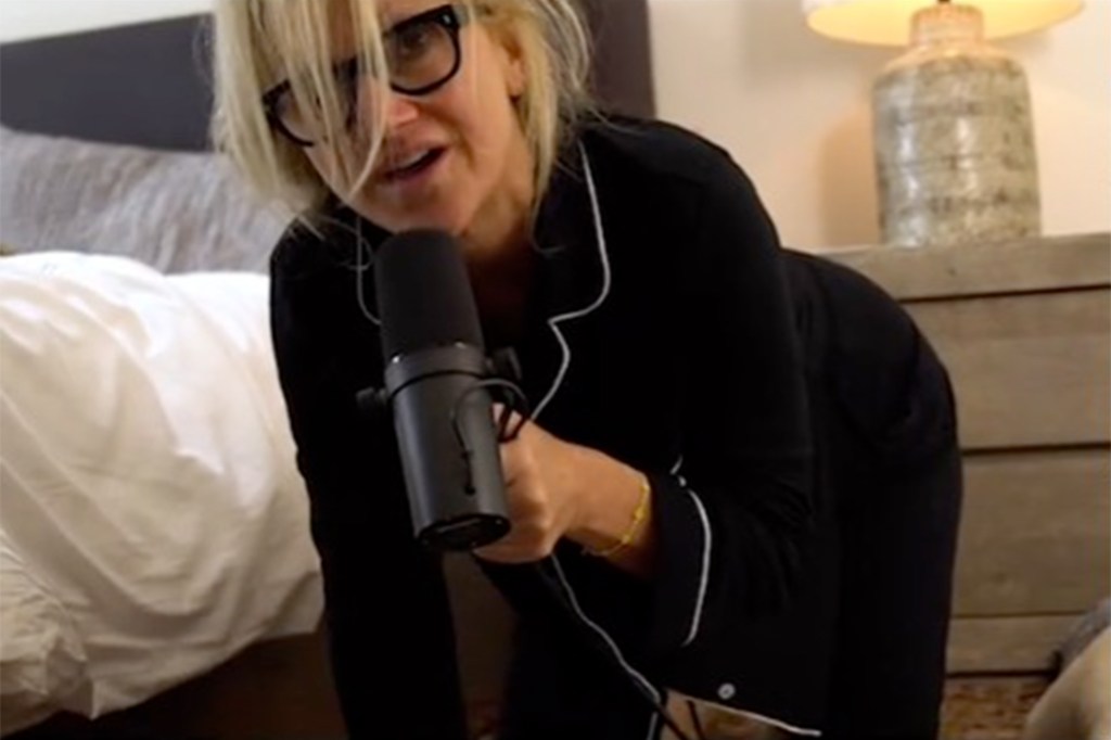 Mel Robbins demonstrating a 'slithering' technique to get out of bed on a wooden floor