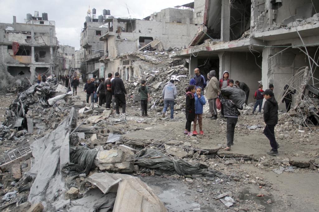 Palestinians gather near buildings destroyed by an Israeli airstrike on Tuesday.