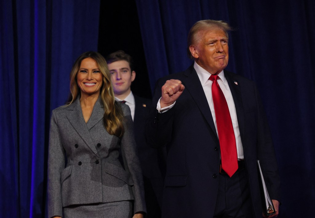 Republican presidential nominee and former U.S. President Donald Trump makes a fist as he takes the stage with his wife Melania and son Barron to address supporters at his rally, at the Palm Beach County Convention Center in West Palm Beach, Florida, U.S., November 6, 2024.