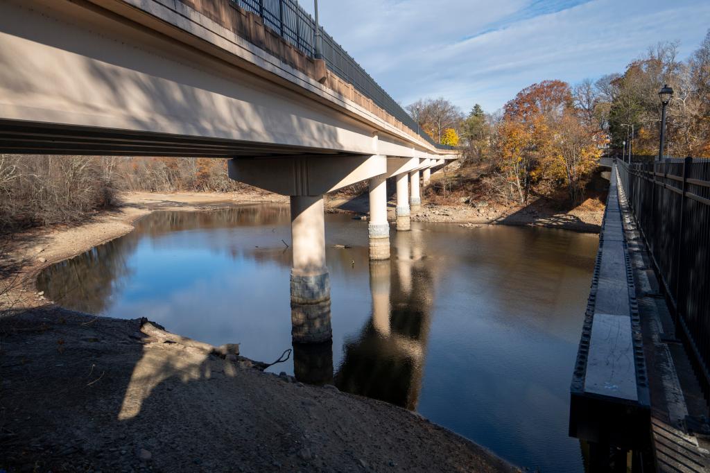 Boonton Reservoir in Parsippany showing low water levels due to drought conditions, with a bridge over the river in the scene