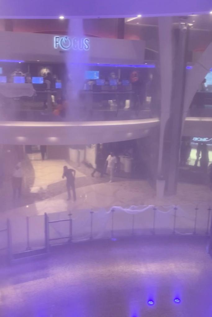 Passengers aboard a Royal Caribbean cruise ship watching a Halloween party as the sprinkler system unintentionally activates, soaking everyone