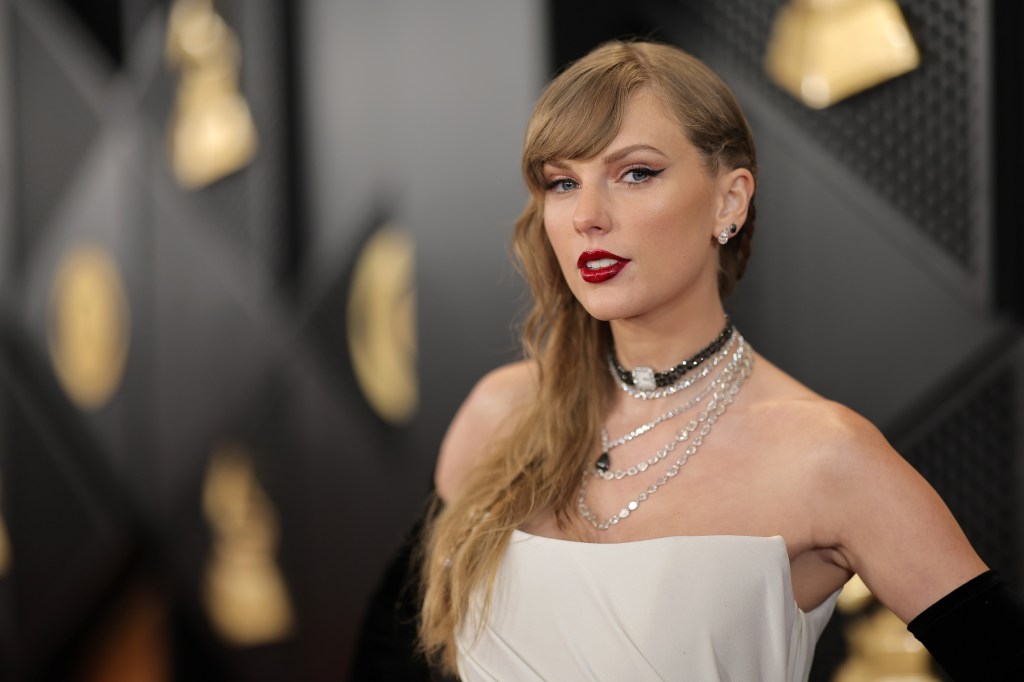 Taylor Swift wearing red lipstick and a white dress at the 66th Grammy Awards in Los Angeles, California, 2024