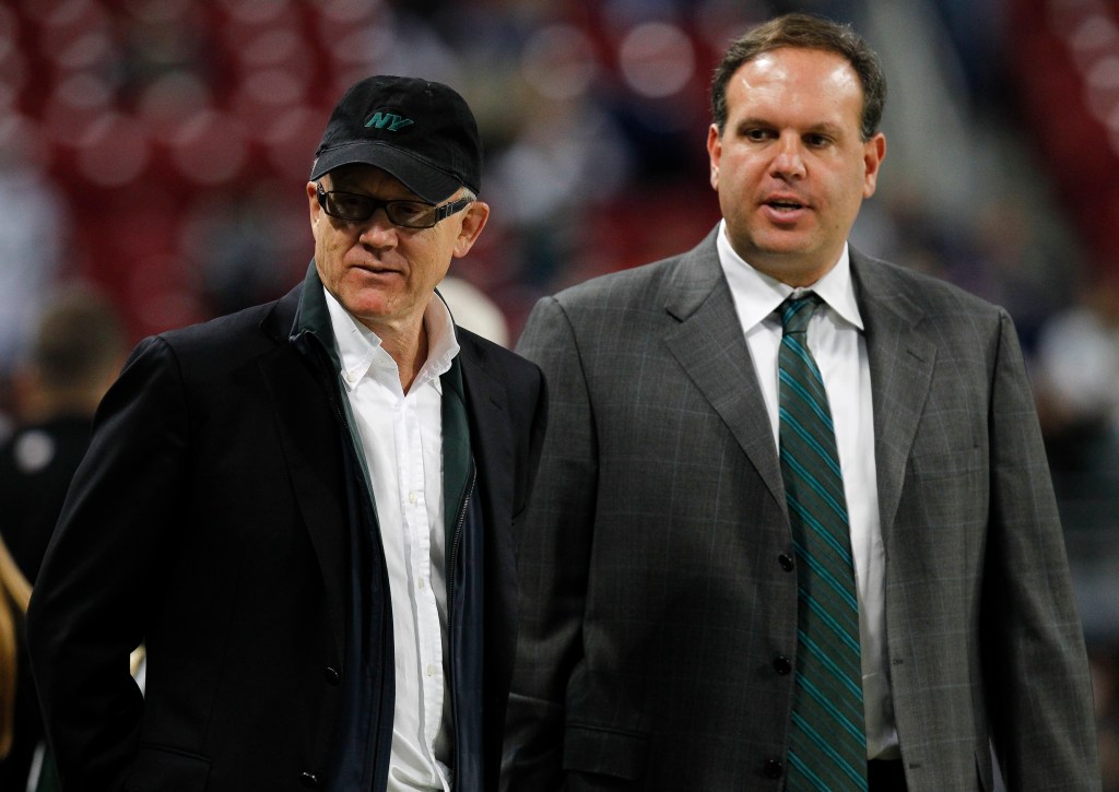 Woody Johnson and Mike Tannenbaum in suits discussing before a Jets game at Edward Jones Dome