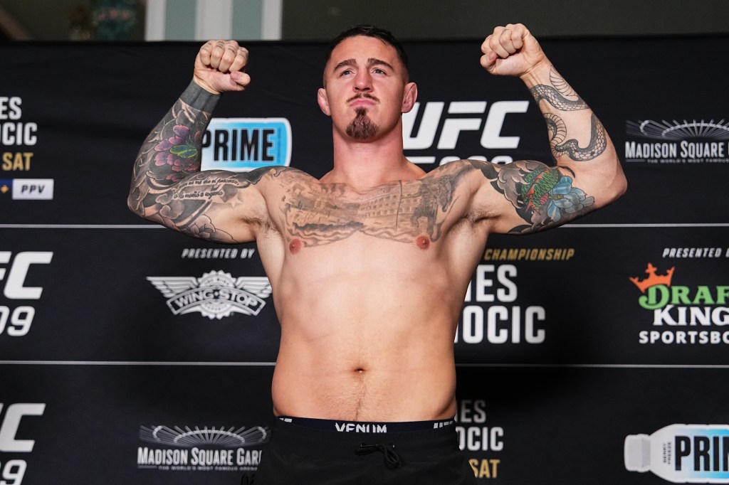 Tom Aspinall poses on the scale during the UFC 309 official weigh-in at the New York Hilton Midtown on November 15, 2024 in New York City. 