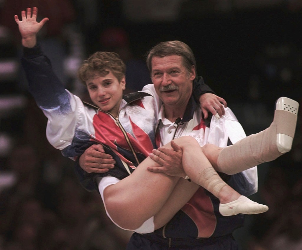 Bela Karolyi carries Kerri Strug during the 1996 Summer Olympic Games. 