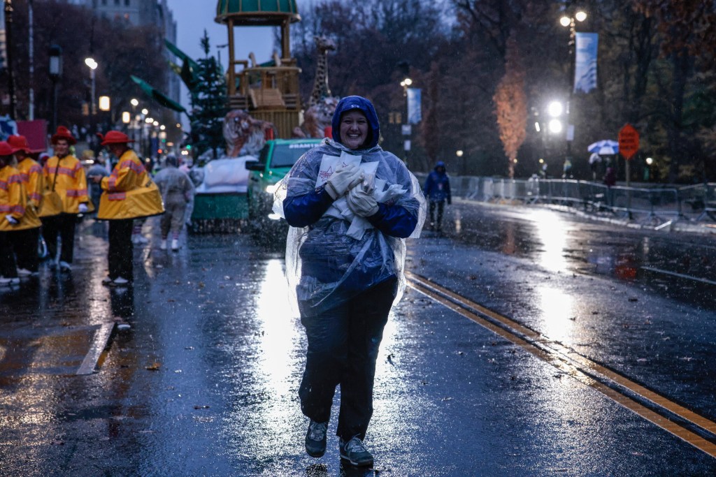 A worker carrying rain cover supplies prior to the Annual Thanksgiving Day Parade in New York City, 2024