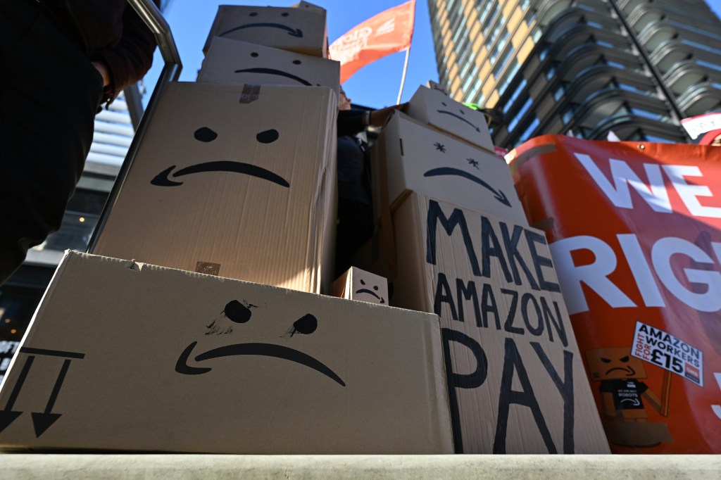 Amazon workers protesting due to wage dispute and poor working conditions outside Amazon's HQ in London on a busy shopping day