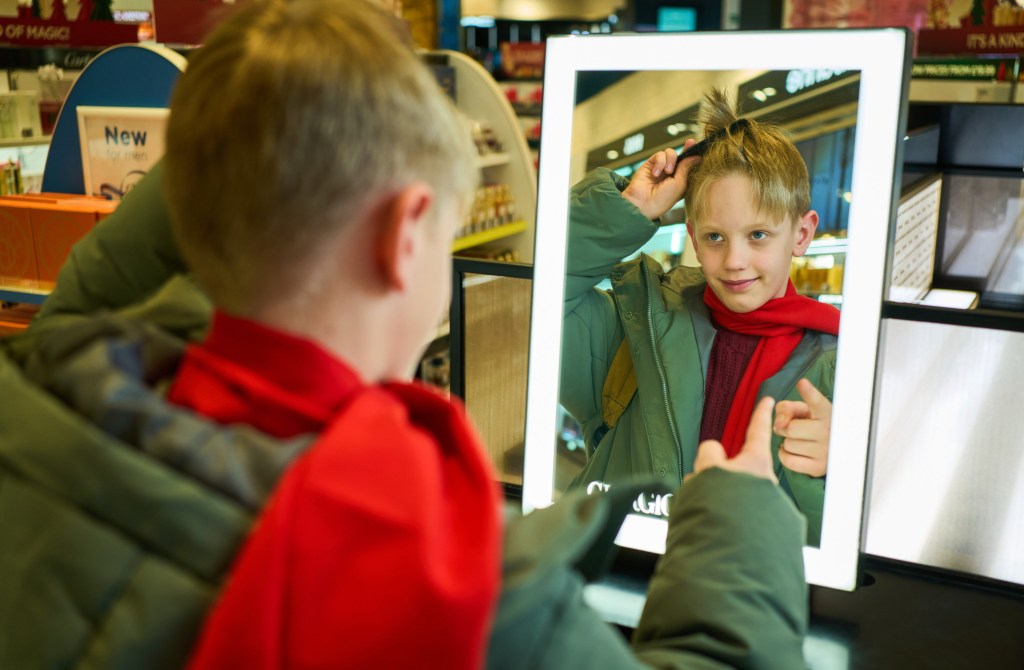 Aleksei Fomkin looking at a mirror in an airport Duty Free shop, reenacting Kevin McCallister's scene from Home Alone