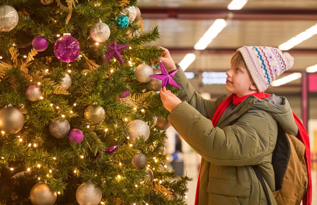 Aleksei Fomkin and Dontrelle Inman recreating a scene from Home Alone at London Luton Airport, decorating a Christmas tree as a reminder for travellers to plan ahead during holidays.