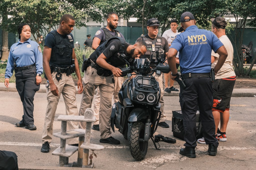 NYPD carrying out a large scale confiscation of unregistered scooters and cars near the a migrant shelter center on Randall's Island.
