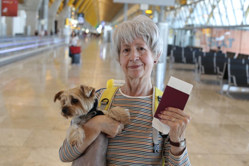 A woman with her dog at the airport. 