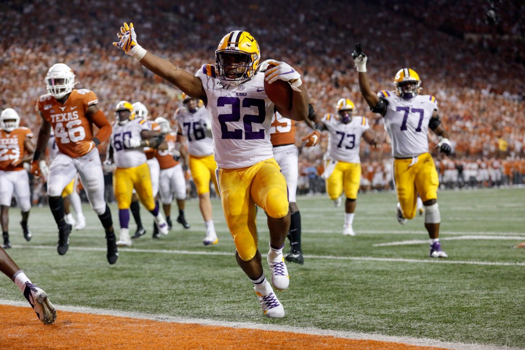 Clyde Edwards-Helaire of LSU Tigers running with his arms raised in celebration of a touchdown at a game against Texas Longhorns, 2019.