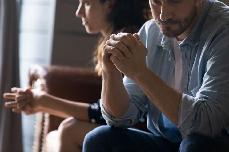 Crop close up of unhappy young couple sit separate have problems in relationship think of breakup or divorce.