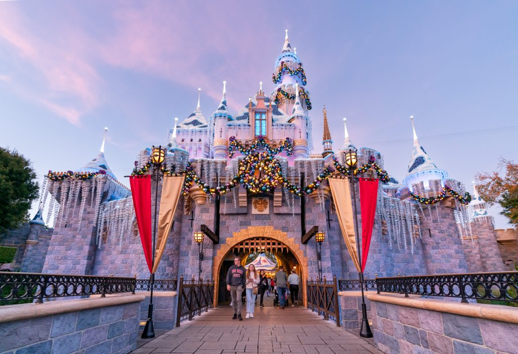 Sleeping Beauty Castle at Disneyland, Anaheim, adorned with holiday lights, with people walking in front, on December 03, 2022.