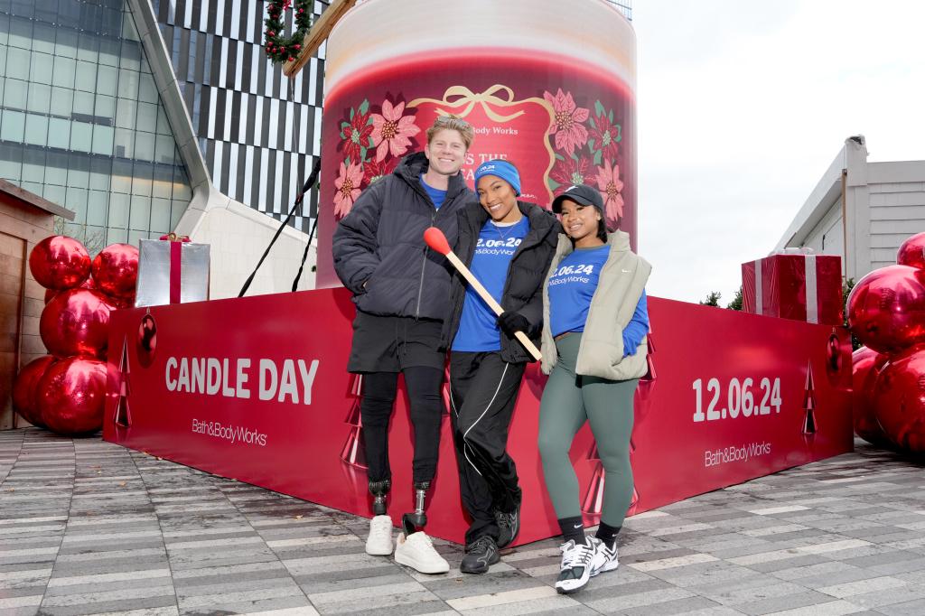 (L-R) Hunter Woodhall, Tara Davis-Woodhall and Jordan Chiles light the candle at the end of the Torch Run as Bath & Body Works counts down to Candle Day in New York City.