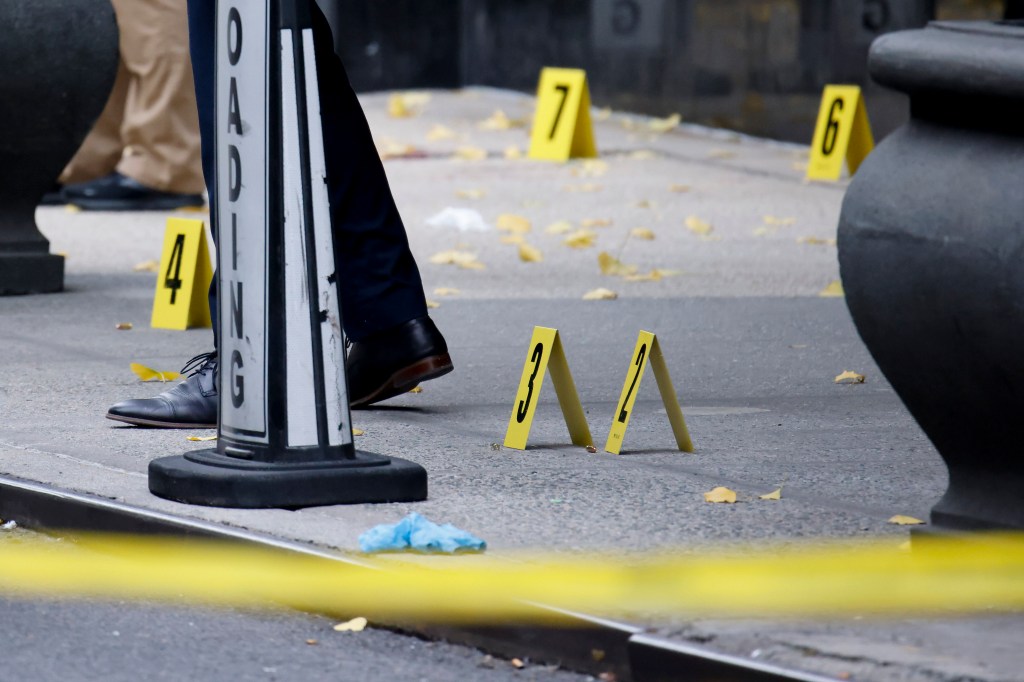 Signs marking bullets on the sidewalk at the scene of the shooting.