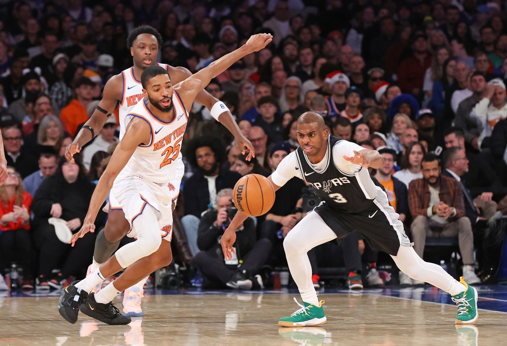 The Knicks' Mikal Bridges (l.) and Spurs' Chris Paul (r.) chase a loose ball on Dec. 25, 2024.