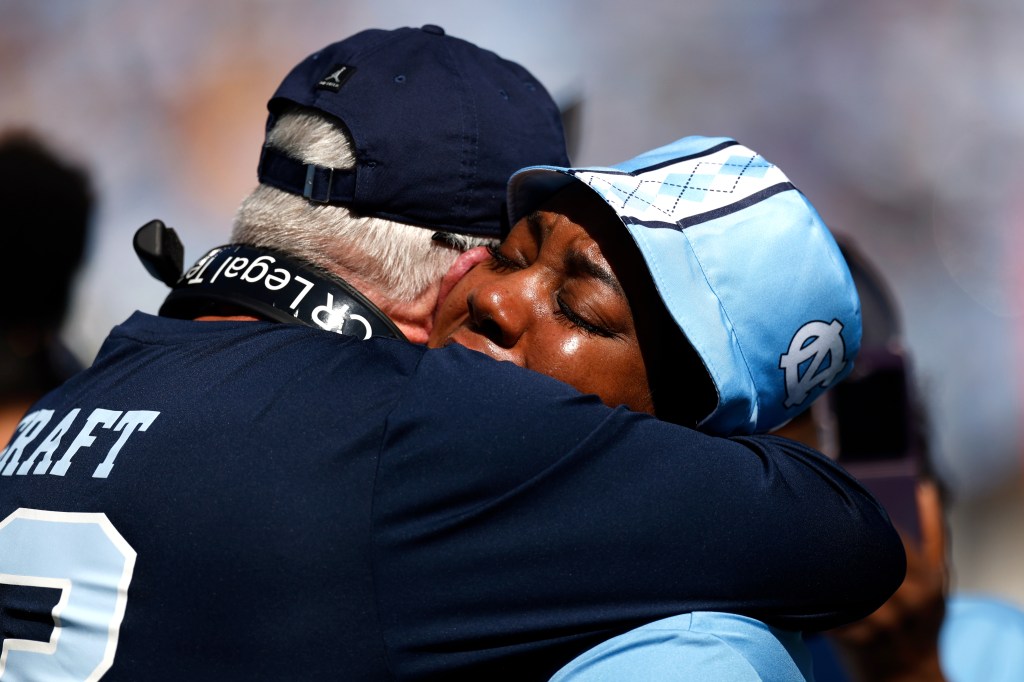 Brown (L) embraces September Craft, mother of North Carolina wide receiver Tylee Craft (not pictured), who was battling Stage 4 lung cancer at the time.